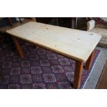 A rustic waxed pine rectangular dining table on square supports