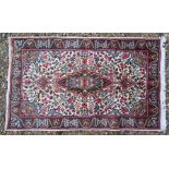 A Persian cream ground Kirman rug, 140 cm x 85 cm