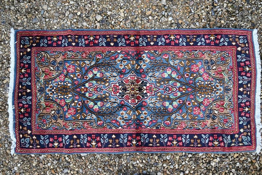 A Persian blue ground Kerman rug, 150 cm x 80 cm