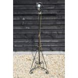 An antique wrought iron adjustable standard lamp