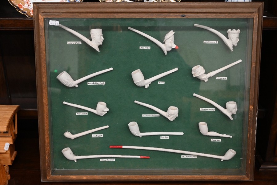 A glazed case displaying a collection of clay pipes