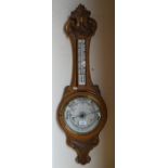 A vintage carved oak Aneroid barometer