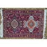 A Caucasian purple ground rug, 176 cm x 119 cm