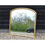 A large arched overmantle mirror in moulded giltwood frame