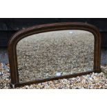 An antique walnut and gilt arched over mantel mirror