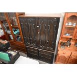 A 19th century Jacobean style dark oak press cupboard on chest