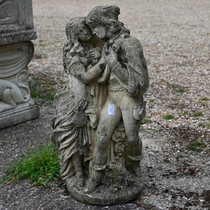 A weathered cast stone garden statue of Romeo & Juliet