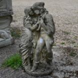 A weathered cast stone garden statue of Romeo & Juliet