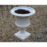 An old cast iron garden urn planter, painted white
