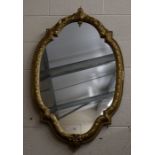 A large wall mirror in foliate carved and moulded quatrafoil gilt frame