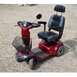 A red Strider ST4D mobility scooter with charger