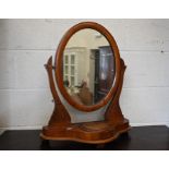 An Edwardian walnut framed oval dressing table mirror