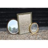 A trio of gilt framed wall mirrors, one rectangular, two oval