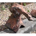 A reconstituted cast stone gothic dragon ridge tile in aged terracotta finish