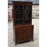 A 19th century Regency style mahogany cabinet bookcase