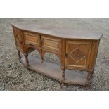 A limed oak sideboard with panelled cupboard doors