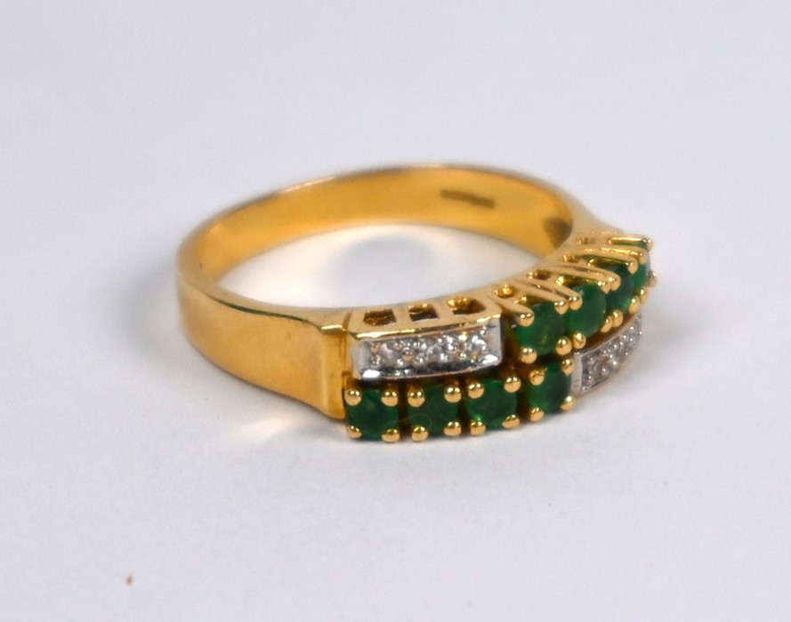 An emerald and diamond dress ring