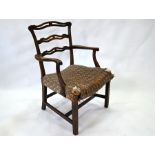 An 18th century oak wavy ladderback elbow chair