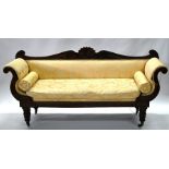 A Regency mahogany framed sofa, with scroll ends and upholstered in yellow material