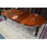 A Victorian style bright mahogany wind-out dining table, with three extension leaves and rounded end