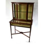 An Edwardian cross-banded re walnut vitrine display cabinet by Maple & Co