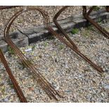 A set of five weathered steel curved garden plant frames