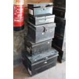 A stack of five variously sized old black tin deed boxes