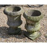 A pair of weathered cast-stone garden planters