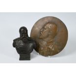 A circular bronze relief plaque and a small bust