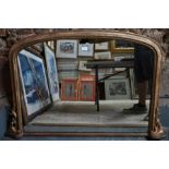 A Victorian arched giltwood framed overmantel