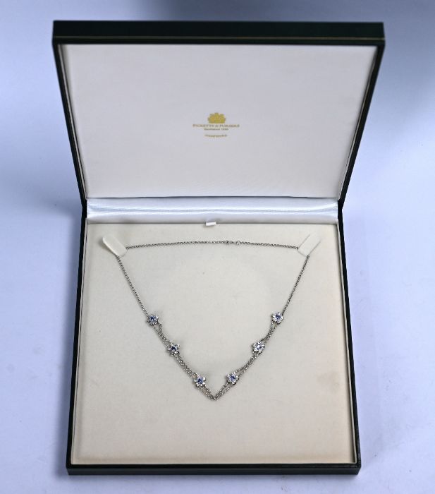 A white metal sapphire and diamond flower necklet,