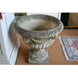 A large weathered cast stone garden urn