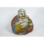 A Chinese polychrome and gilt decorated figure of Budai, 26.5 cm high