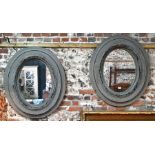 A pair of washed distressed grey patinated oval wall mirrors