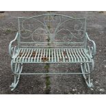 A painted wrought metal two seater rocking garden bench of scroll design