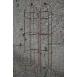 A pair of weathered steel ball head obelisks