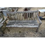 A weathered and slatted teak garden three seater bench