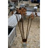 A set of ten weathered steel garden ground spikes with poppy-head finials