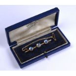 An Edwardian bar brooch set with three claw-set cabochon moonstones