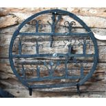 An antique wrought iron grate-mounting trivet