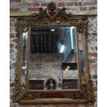 An antique gilt framed cushion mirror