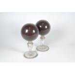 A pair of 19th century globular blown-glass wig-stands