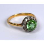 A green tourmaline and diamond circular cluster ring