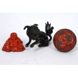 A Chinese cinnabar box and cover, bronze scroll weight and lacquered Budai figure (3)