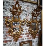 A pair of antique Italian giltwood framed cartouche mirrors