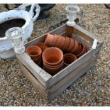 A crate containing a quantity of terracotta planting pots