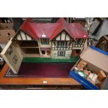 A vintage Tri-Ang wood and tin-plate dolls house with Harrods retailed furniture