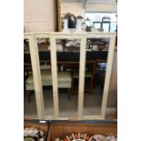 A trio of cream painted moulded framed mirrors
