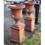 A pair of weathered terracotta garden urns