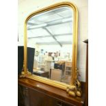 A large Victorian style gilt framed arched overmantle mirror